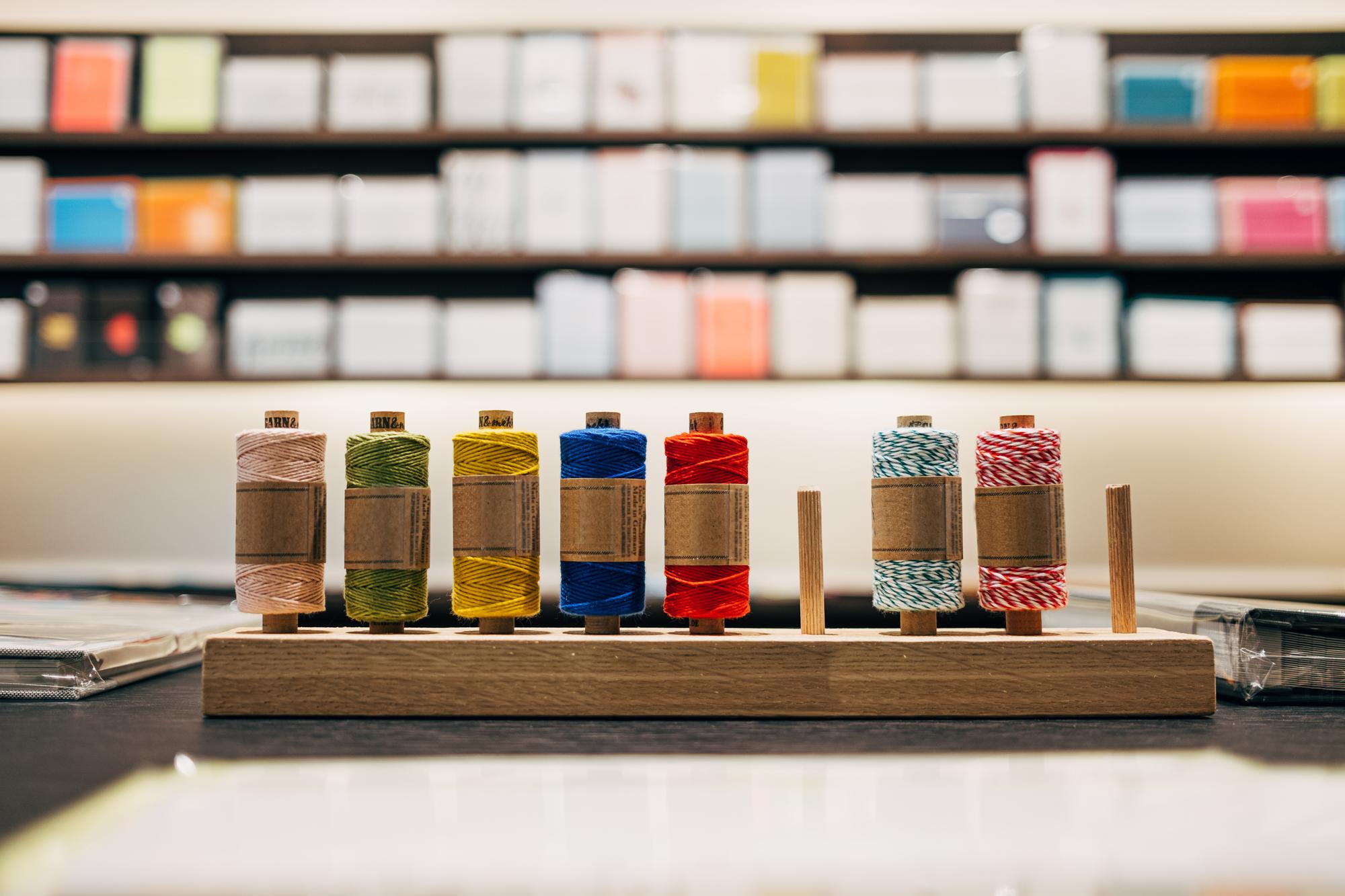 Studio table with threads, needles and embroidery samples